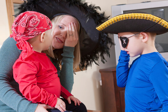 Woman using American Sign Language to communicate with her sons dressed as pirates at Halloween