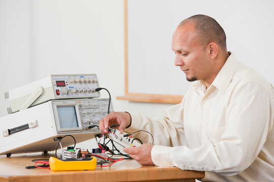 Engineering student preparing an electrical experiment on protoboard