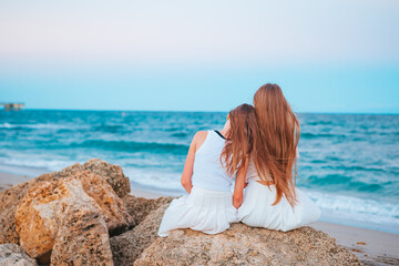 Adorable teen girls on tropical seashore at sunset
