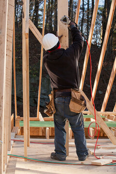 Carpenter nailing a temporary brace in place