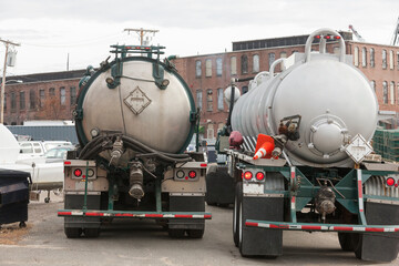 Two hazardous waste tanker trucks for picking up petroleum from ships in harbor