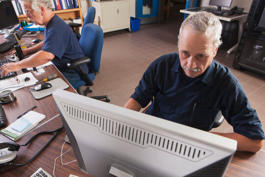 Two engineers on computers starting up the water treatment plant in program for supervisory control and data acquisition