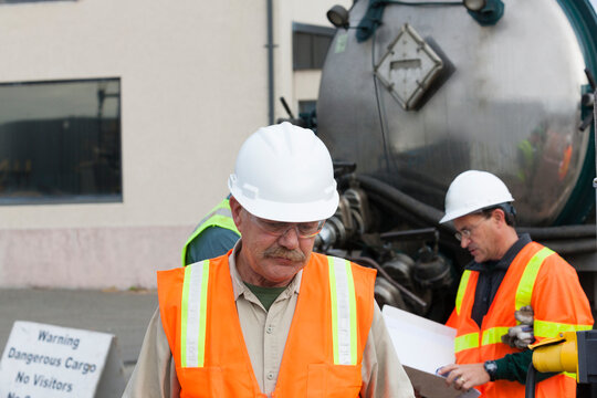 Environmental engineers working with tank truck at hazardous waste cleanup site