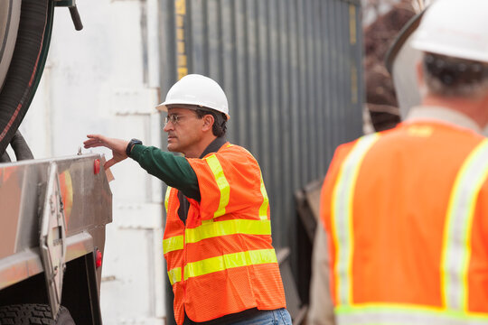Environmental engineer reaching for log book at tanker truck