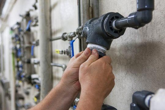 Engineer putting a rebuilt O2 electrochemical sensor probe into service on piping in water treatment plant