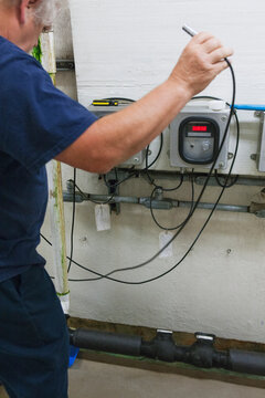 Engineer connecting O2 electrochemical sensor probe cable to meter in water treatment plant