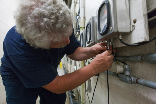 Engineer connecting O2 electrochemical sensor probe cable to meter in water treatment plant
