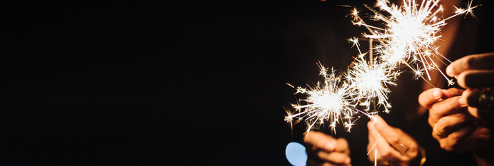 hand holding sparkler isolated on black background symbolizes the new year.This image contains copy space.