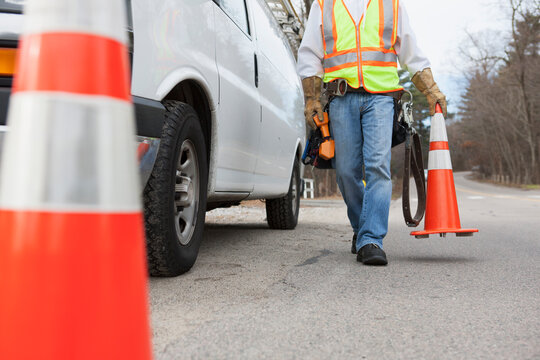 Communications worker placing traffic cones around his truck