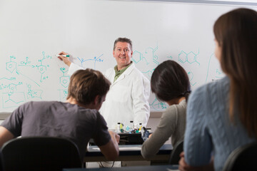 Students seated in an engineering classroom listening to professor discuss chemical Benzene ring bonds