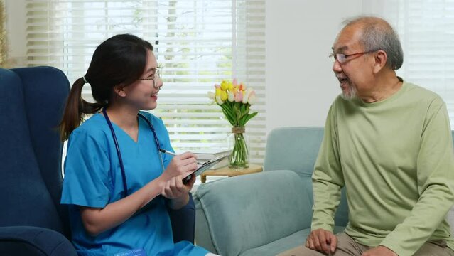 Asian young nurse writing prescription during home visit sick elder old man, Senior man takes doctor at home telling about health complaints, health care and medical concept