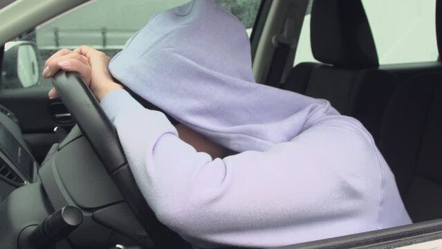 a woman trying to rest in the car. wants to sleep but she has a cold. Road trip concept.