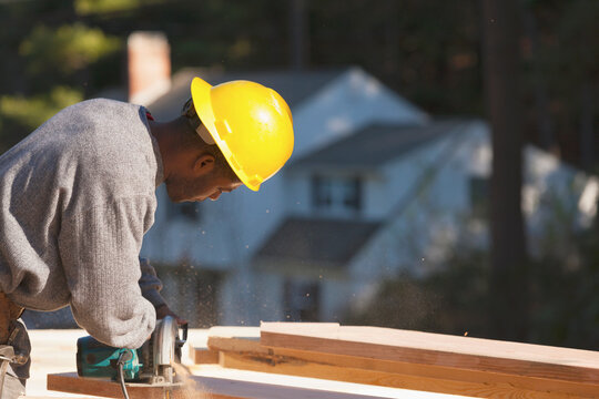Carpenter cutting bevel on rafter with a circular saw