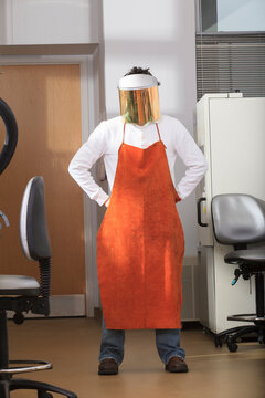 Engineering student wearing leather protective smock and splash guard in chemical analysis laboratory