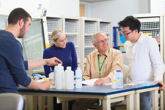 Engineering professor discussing learning objectives with students in a chemical laboratory