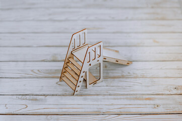 Close-up of a small, miniature wooden homemade children's slide from a playground constructor kit. Photography, design, decor.