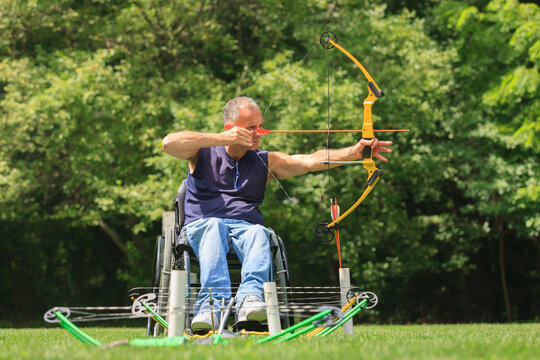 Man in a wheelchair with a bow and arrow