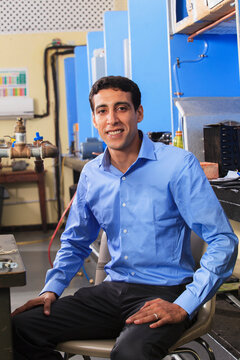Student beside furnace fuel lines in HVAC classroom