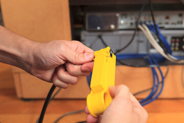 Cable installer using a tool to remove the outer insulation sheath from a cable