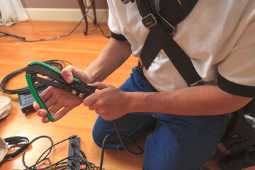 Cable installer using a crimping tool to add a new cable connector to a cable