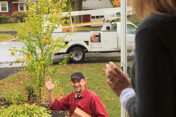 Cable installer leaving and waving to homeowner