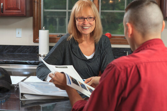 Cable Installer Reviewing Service Plans With Home Owner