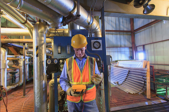 Engineer in electric power plant using a voltmeter to verify sensor readings