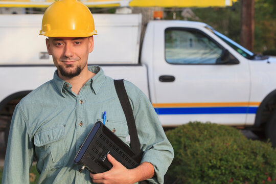 Portrait of lineman with cable box going to the house
