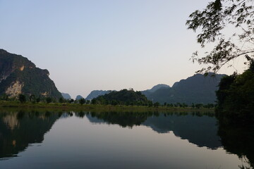 Fototapeta na wymiar Sunset over the lake and mountains in the background in Vietnam