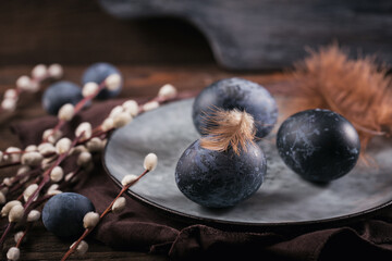Easter eggs painted by hand in blue color with marble stone effect on dark wooden background. Chicken and quail eggs for catholic and orthodox easter holiday