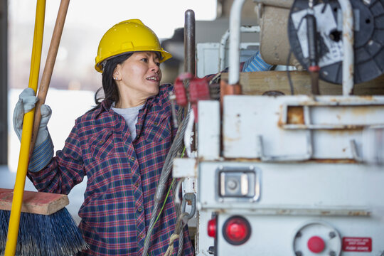 Female power engineer putting tools into a bucket truck
