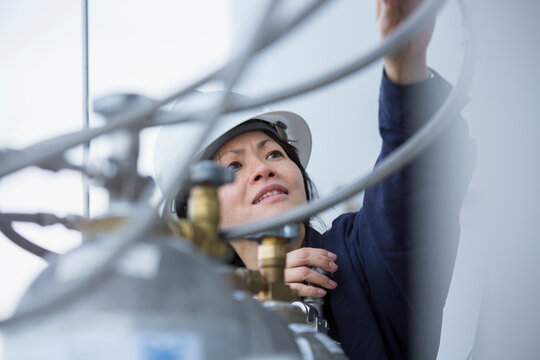 Female power engineer checking injectors with compressed gas at power station
