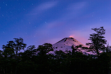 Villarrica volcano glowing in the dark - volcano with illuminated fumaroles, surrounded by stars at...