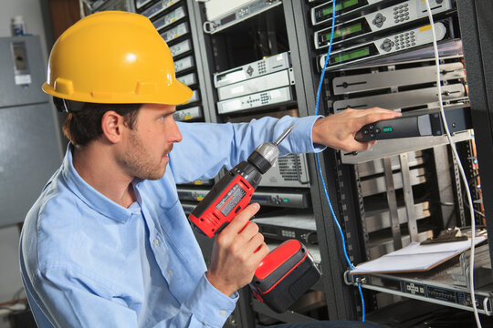 Network engineer installing cable equipment in rack