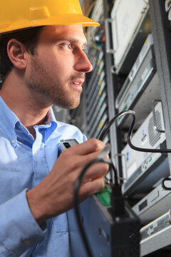 Network engineer installing cable equipment in rack