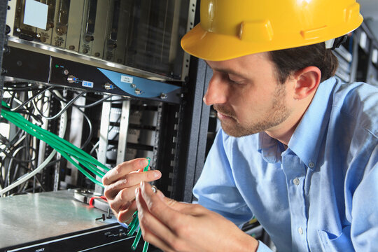 Network engineer examining cable for termination