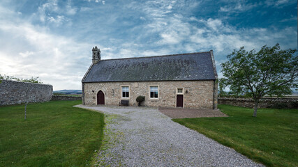 New Spynie Parish Church is a small T-plan structure, located in small grounds alongside a quiet, rural road. 