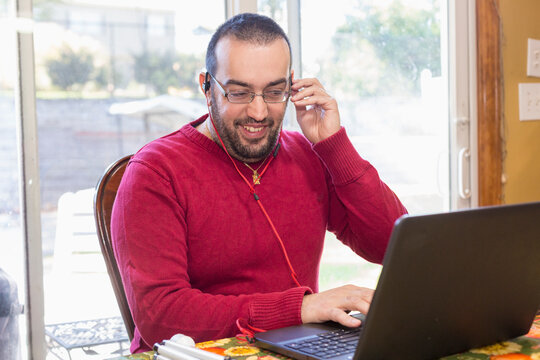 Man with Visual Impairment listening  to music on his computer