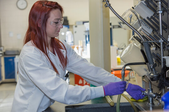Lab chemist flushing tubing with distilled water