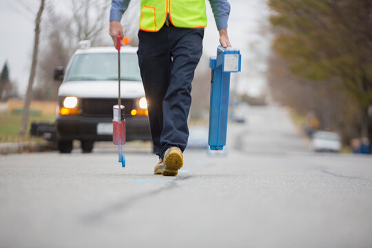 Water department technician marking underground location of water pipes
