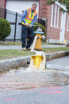 Water department technician opening fire hydrant to flush water mains
