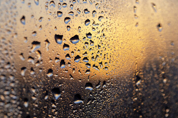 Magnificent sunset through the drops on the glass