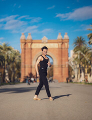 Young man dancing classic ballet in the streets of Barcelona with a beautiful background and light