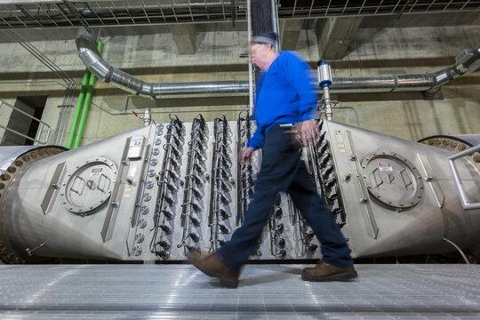 Engineer walking by water treatment plant ultraviolet ionization treatment room