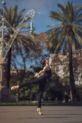 Obraz premium Young man dancing classic ballet in the streets of Barcelona with a beautiful background and light