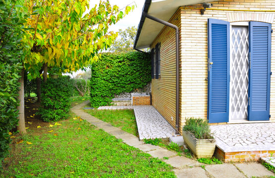 villa con giardino perimetrale con siepi e alberi in autunno