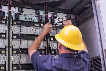 Engineer connecting energy storage batteries for back up power to an electric power plant