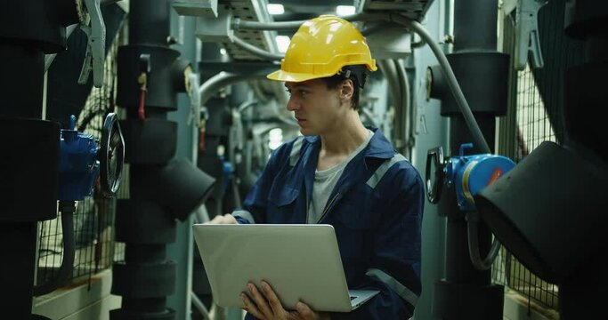 Professional Inspector Engineer foreman in hardhat and uniform with laptop working checking the valve pipelines and recheck system data spec on rooftop of construction Industrial site