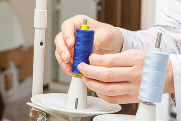 Adjusting the sewing machine, threads in female hands