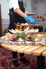 the waiter serves a table with snacks at the buffet